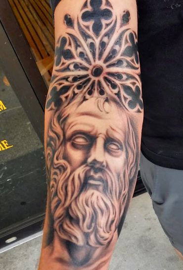 Black and grey statue forearm tattoo